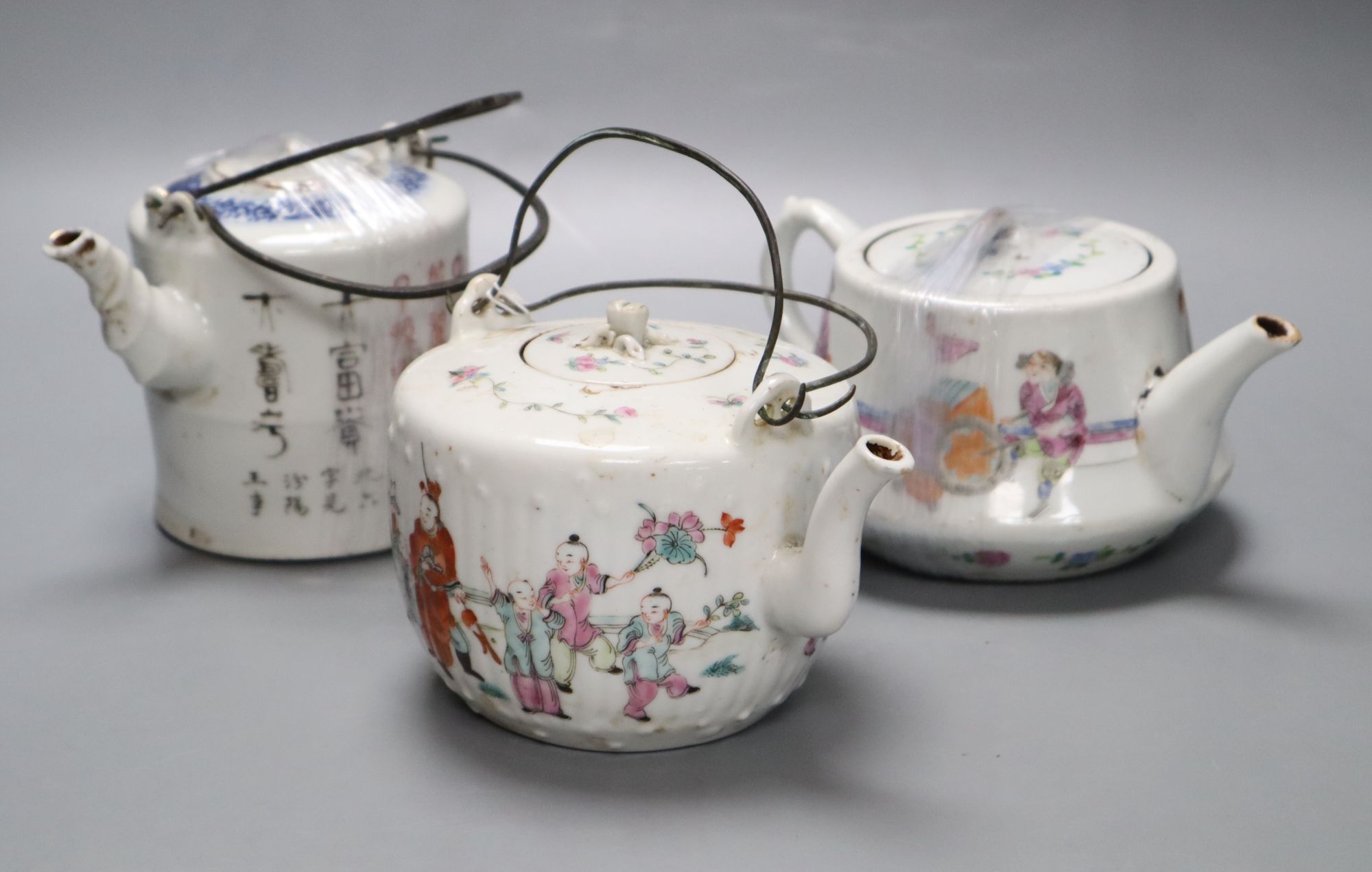 Two Chinese famille rose teapots and covers, and a calligraphic teapot, tallest 10cm